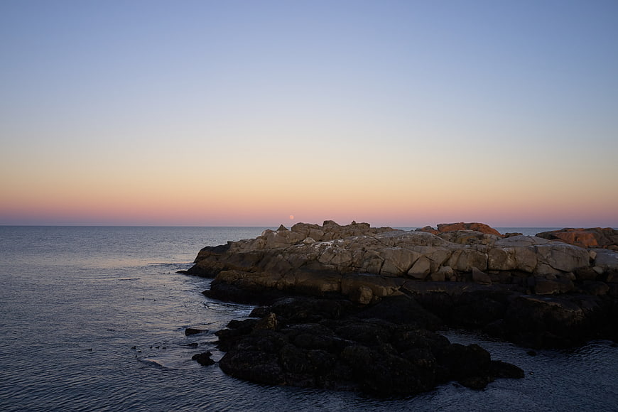 Serene Sunset Over Rocky Coastal Shoreline