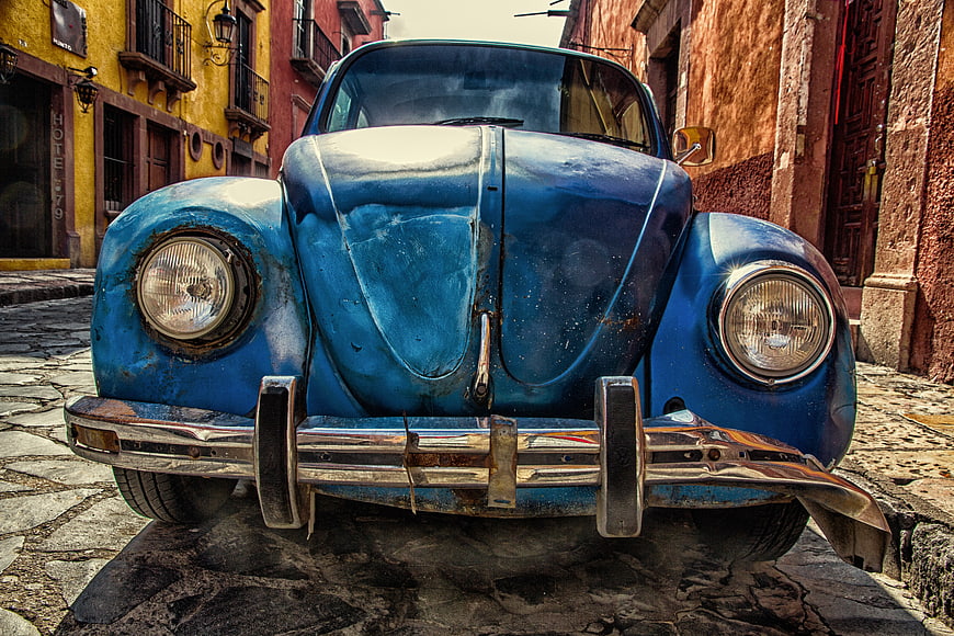 Vintage Blue Volkswagen Beetle on Cobblestone Street