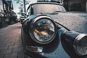 Close-up of Vintage Black Car Headlight with Raindrops