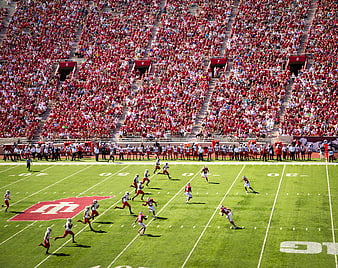 Wide angle view of college football game in packed stadium