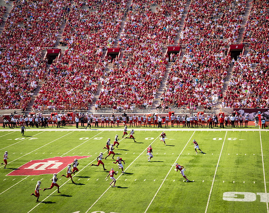 Wide angle view of college football game in packed stadium