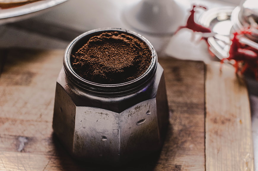 Ground Coffee in Moka Pot Base on Wooden Table