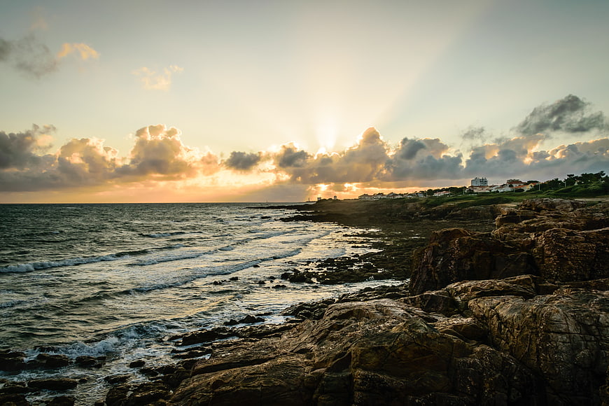 Dramatic Sunset Over Rocky Coastal Cliffs and Ocean Waves