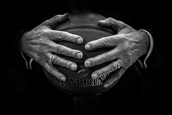Black and white close-up of elderly hands holding a Spalding basketball