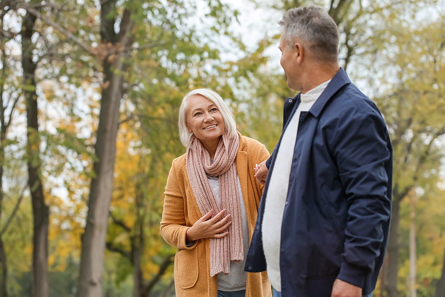 Happy Senior Couple Walking and Talking in Autumn Park