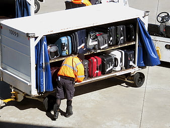 Airport Ground Crew Loading Luggage Onto Baggage Cart