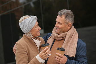 Happy Senior Couple Drinking Coffee Outdoors in Winter