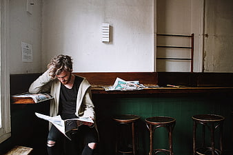 Man reading magazine in vintage cafe interior