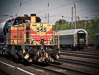 Yellow and red diesel locomotive on railway tracks