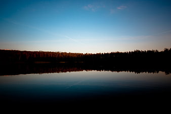 Serene Lake Reflection at Dusk with Forest Silhouette