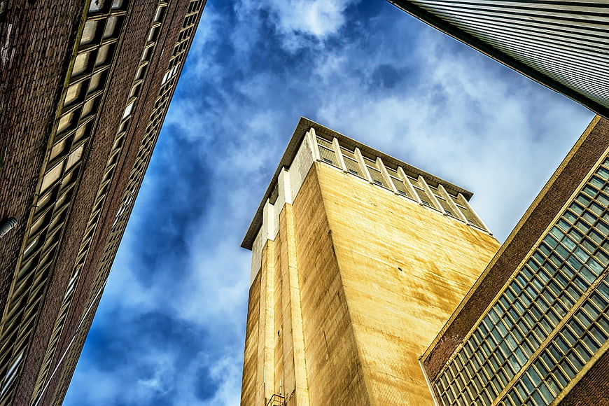 Low angle view of industrial buildings against blue sky