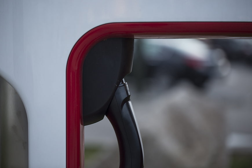 Close-up of electric vehicle charging connector at a red station