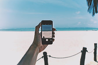 Hand Holding Smartphone Photographing Tropical Beach