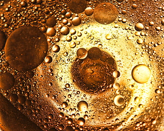 Macro shot of golden oil bubbles and liquid texture