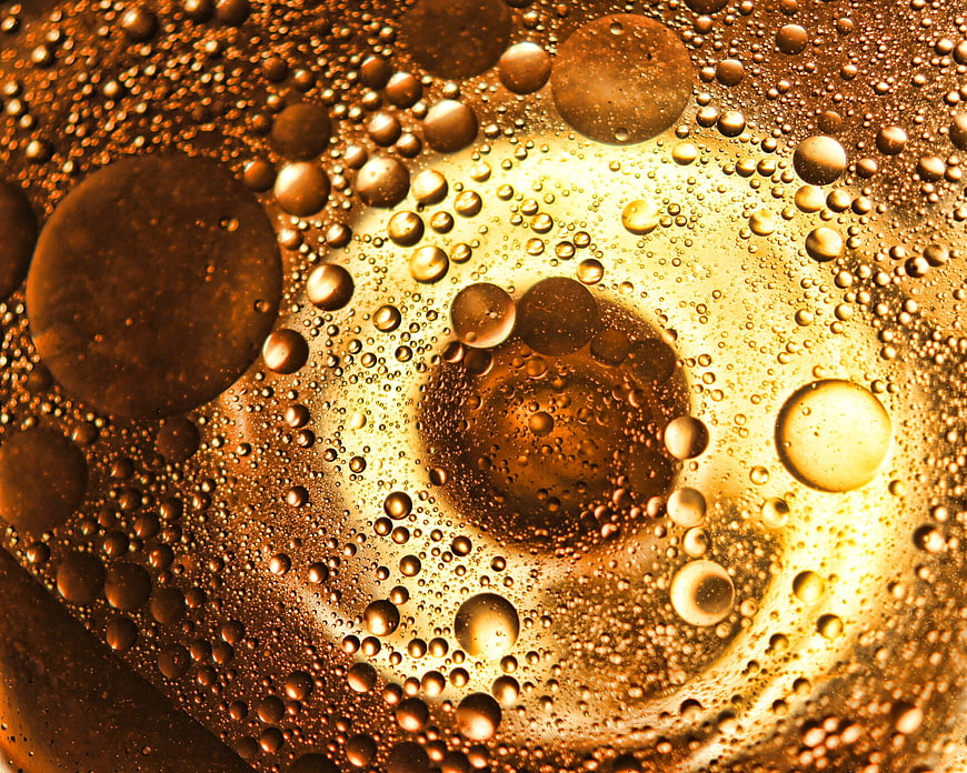 Macro shot of golden oil bubbles and liquid texture