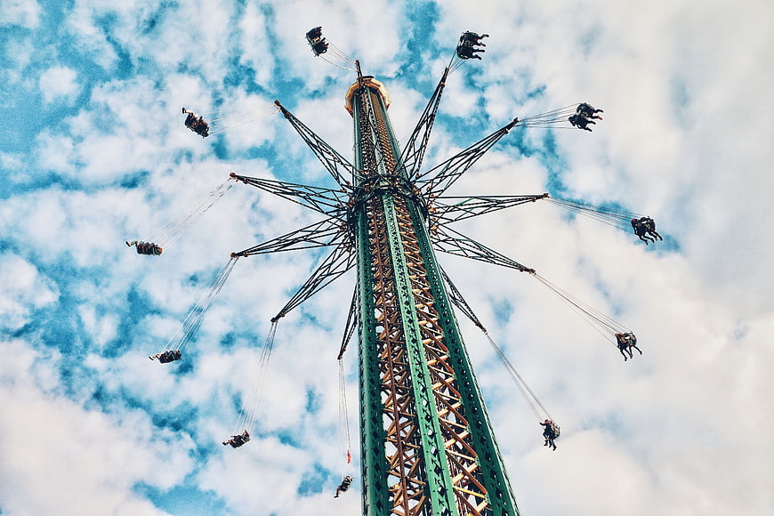 Low angle view of tall swing ride against blue sky