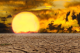 Dramatic sunset over cracked dry earth landscape