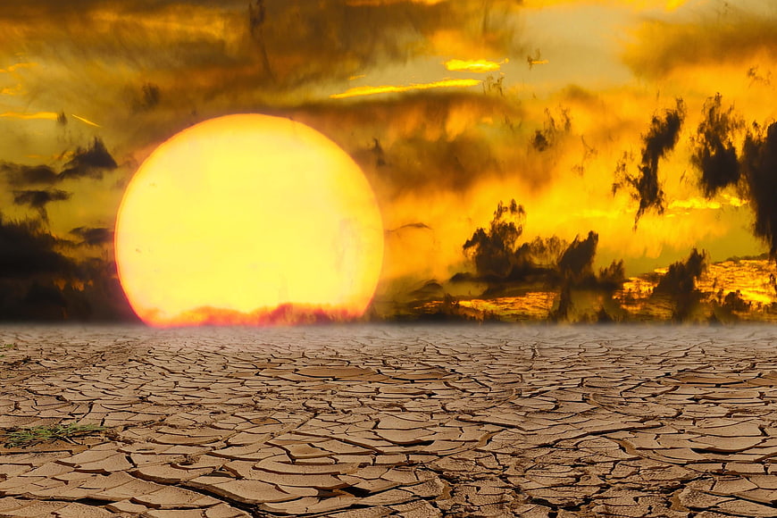 Dramatic sunset over cracked dry earth landscape