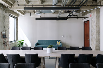 Modern Industrial Office Interior with Conference Table and Teal Sofa