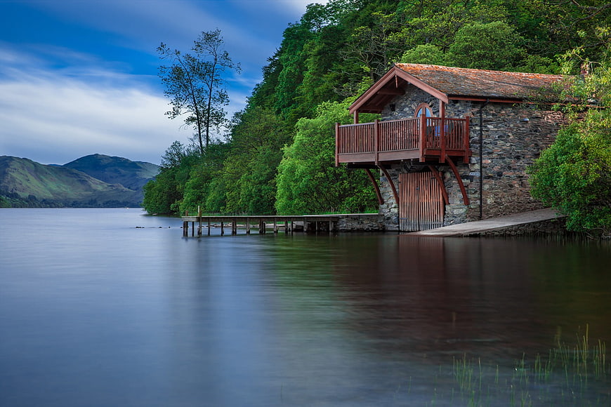 Stone boathouse with wooden jetty on serene lake