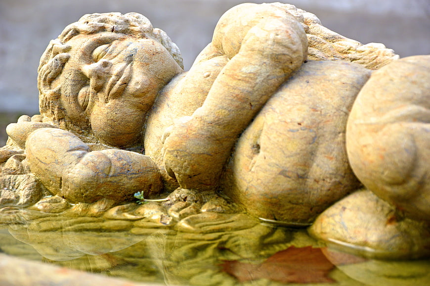 Weathered Stone Putto Sculpture Reclining in Water Feature