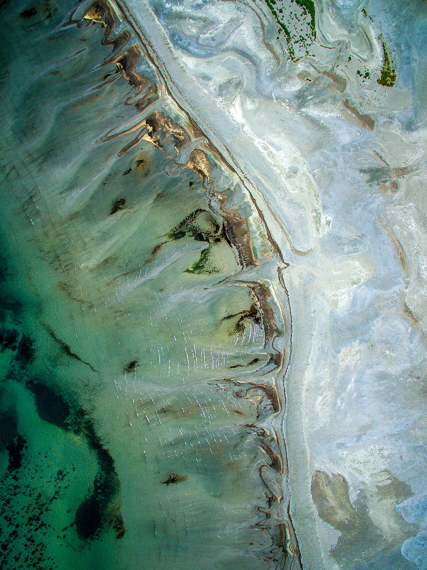 Aerial view of turquoise water and white sand patterns