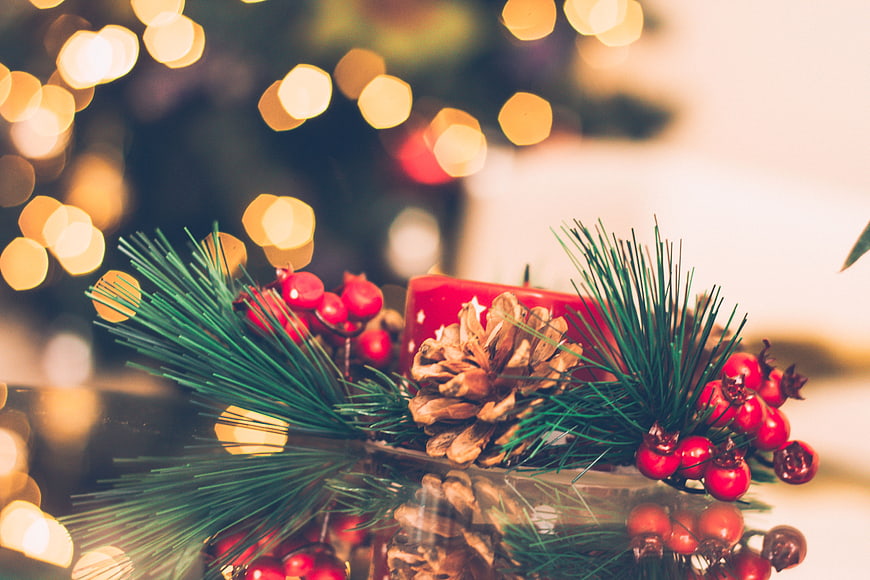Christmas pinecone and berry decoration with bokeh lights