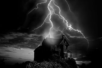 Dramatic Lightning Strike Over Silhouetted House at Night