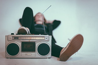 Woman relaxing on floor with vintage silver boombox radio