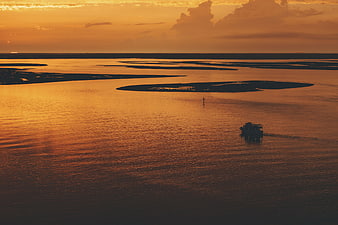Aerial View of Boat on River at Golden Sunset