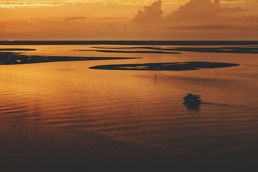 Aerial View of Boat on River at Golden Sunset
