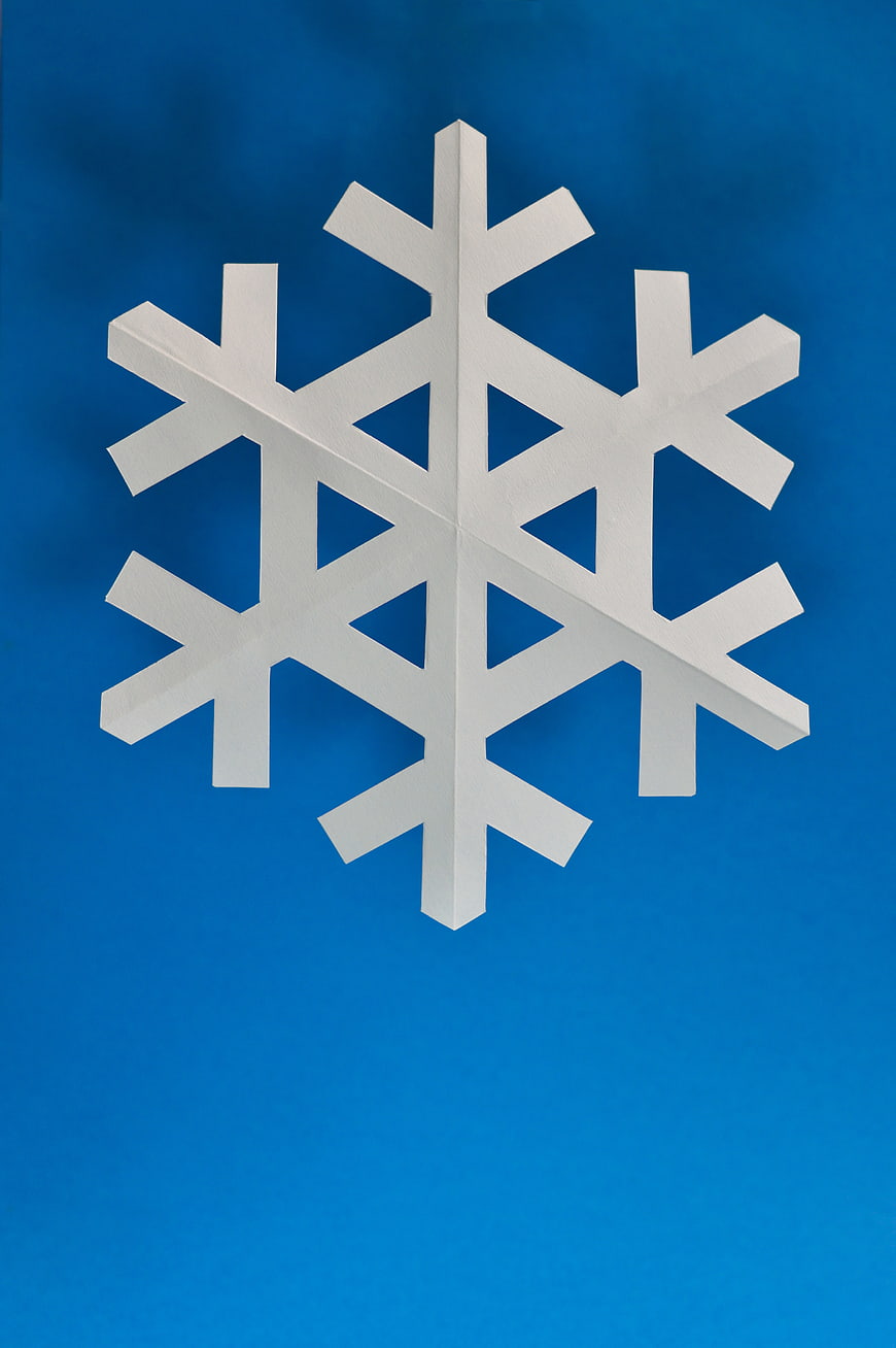 White Paper Snowflake on Blue Background