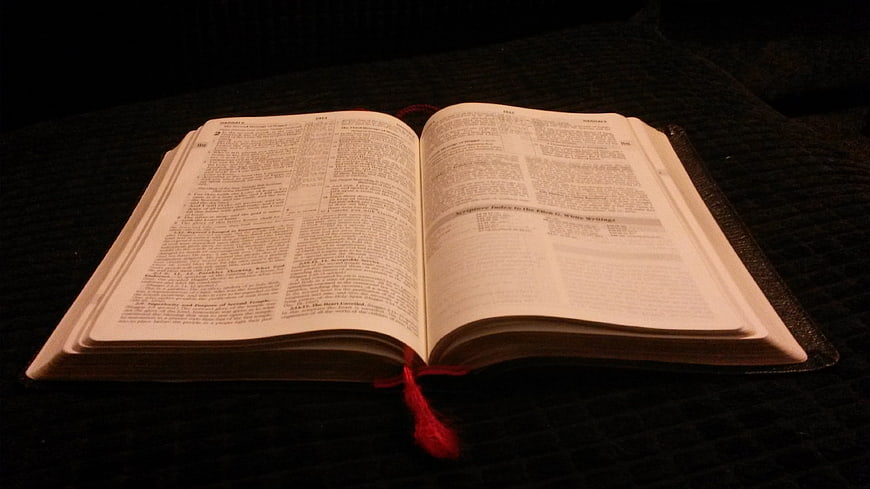 Open Bible with Red Bookmark on Dark Background