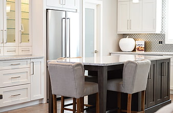 Modern kitchen island with white marble top and gray bar stools