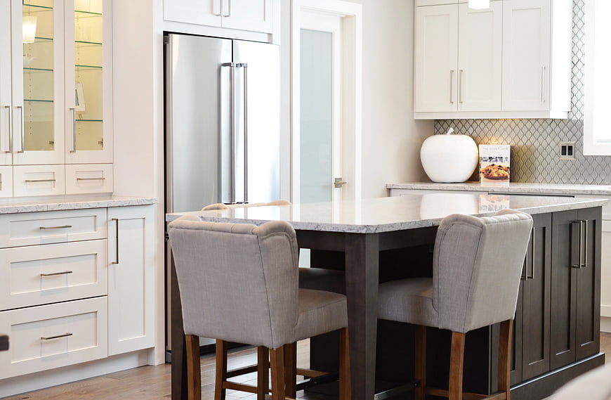 Modern kitchen island with white marble top and gray bar stools