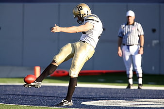 American Football Player Kicking Field Goal on Blue Turf
