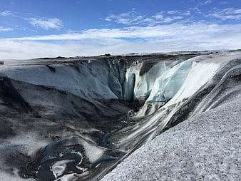 Aerial view of glacier crevasse with meltwater stream in Iceland