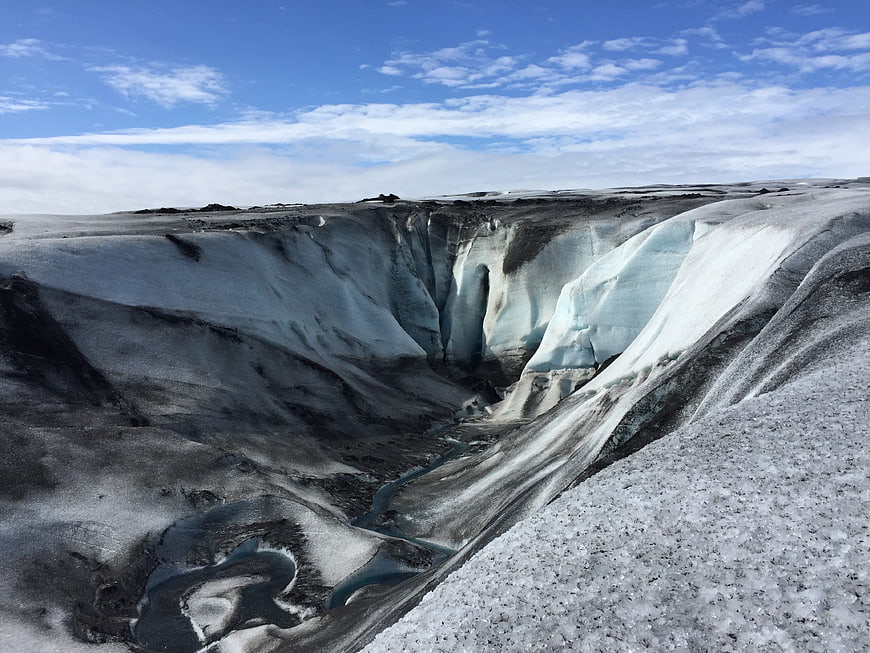 Aerial view of glacier crevasse with meltwater stream in Iceland