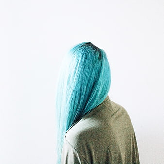 Woman with vibrant blue hair from behind on white background