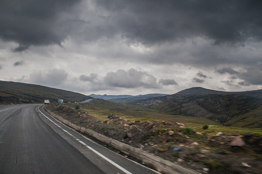 Winding Mountain Road Under Dramatic Stormy Clouds