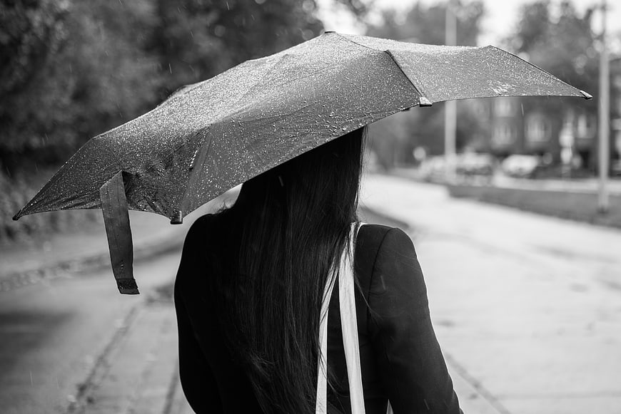 Woman with umbrella waiting in the rain