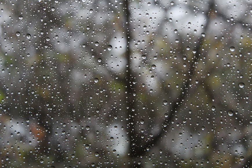 Raindrops on a window with a blurred outdoor background