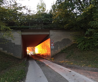 Sunset light illuminating concrete underpass tunnel path