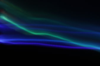 Abstract blue and green neon light streaks on black background