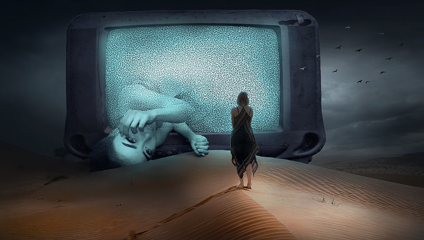 Surreal woman facing giant TV in desert landscape