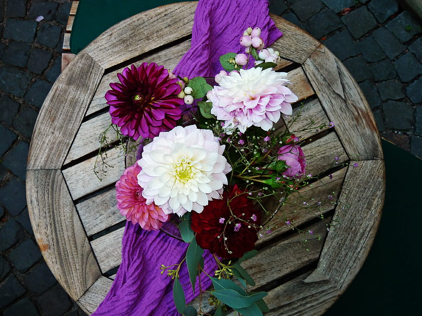 Overhead view of colorful dahlia bouquet on rustic wooden table
