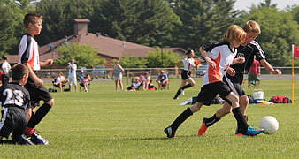 Youth Soccer Boys Competing for Ball on Grass Field