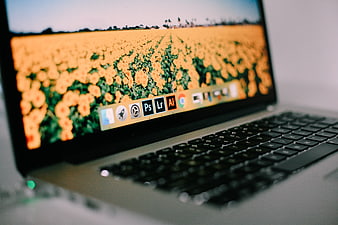 Laptop displaying Adobe Creative Cloud apps on macOS dock