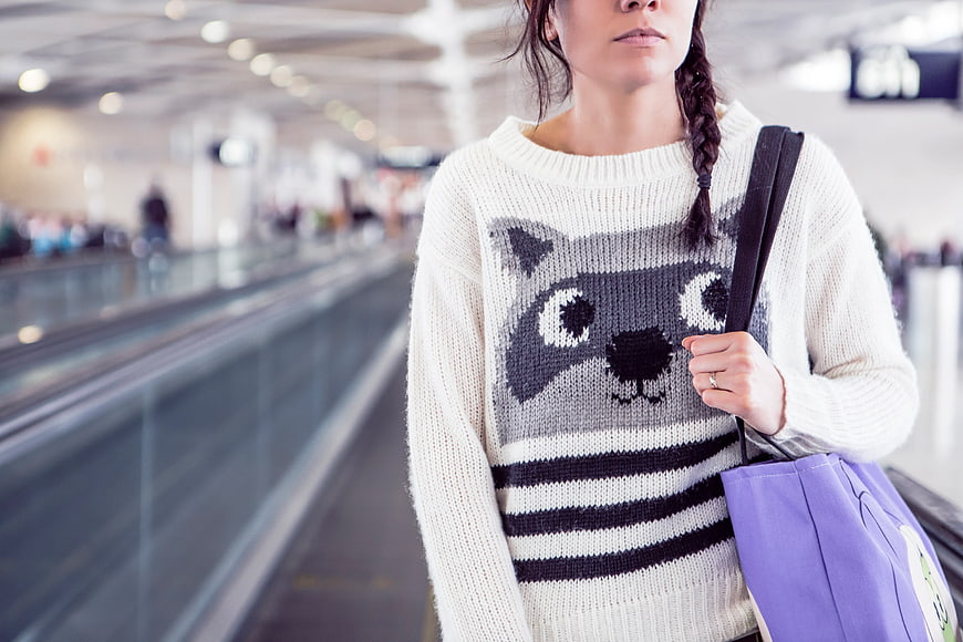 Woman in Cat Sweater Walking in Airport Terminal