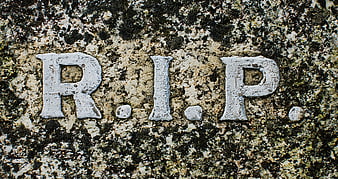 Close-up of R.I.P. inscription on weathered granite gravestone